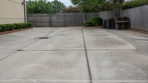 Service yard slab assessed where heavy vehicles have broken it up in Savannah, GA, under bright midday cloud.